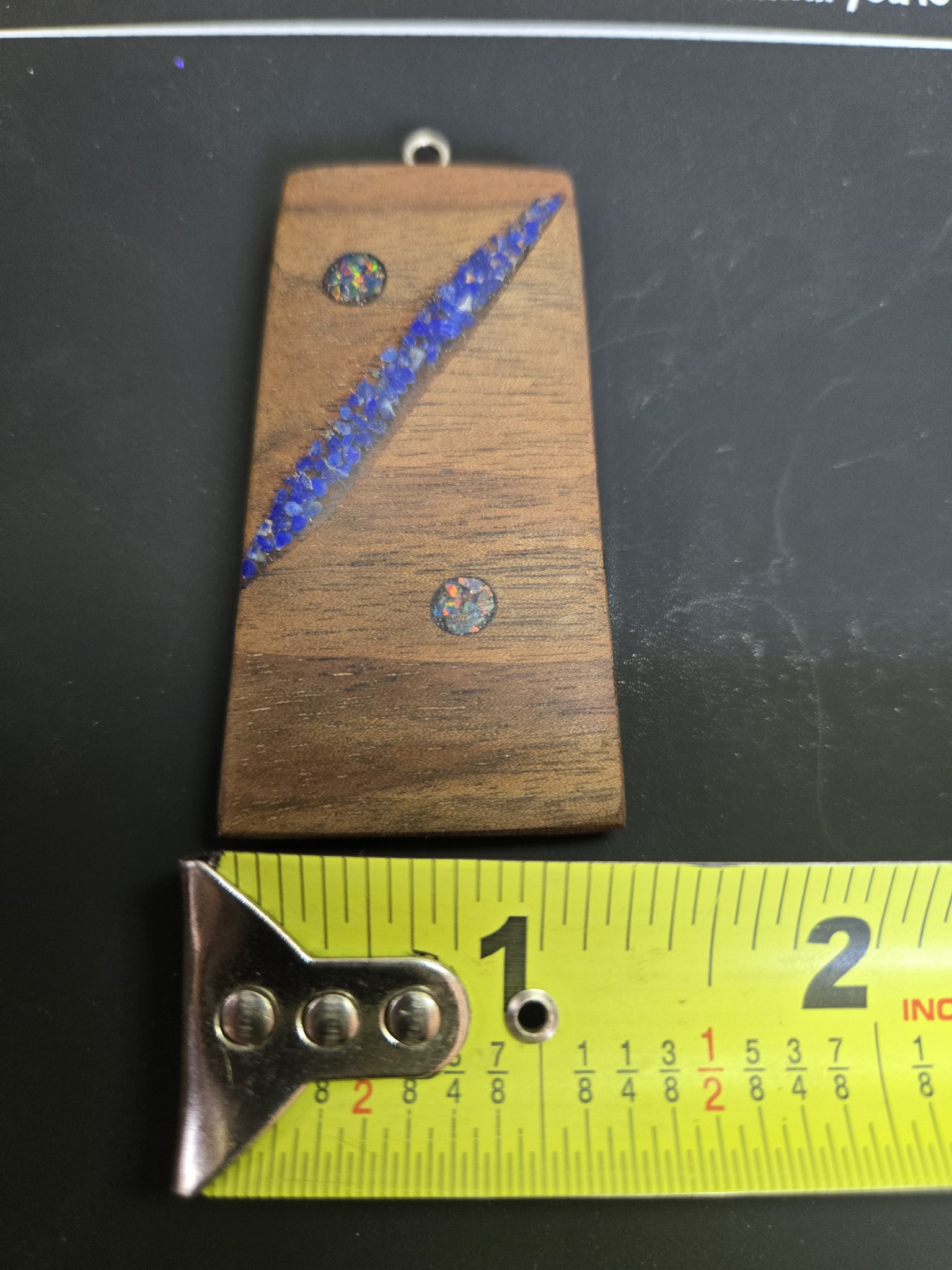Walnut lapis and opal pendant above a tape measure showing its width