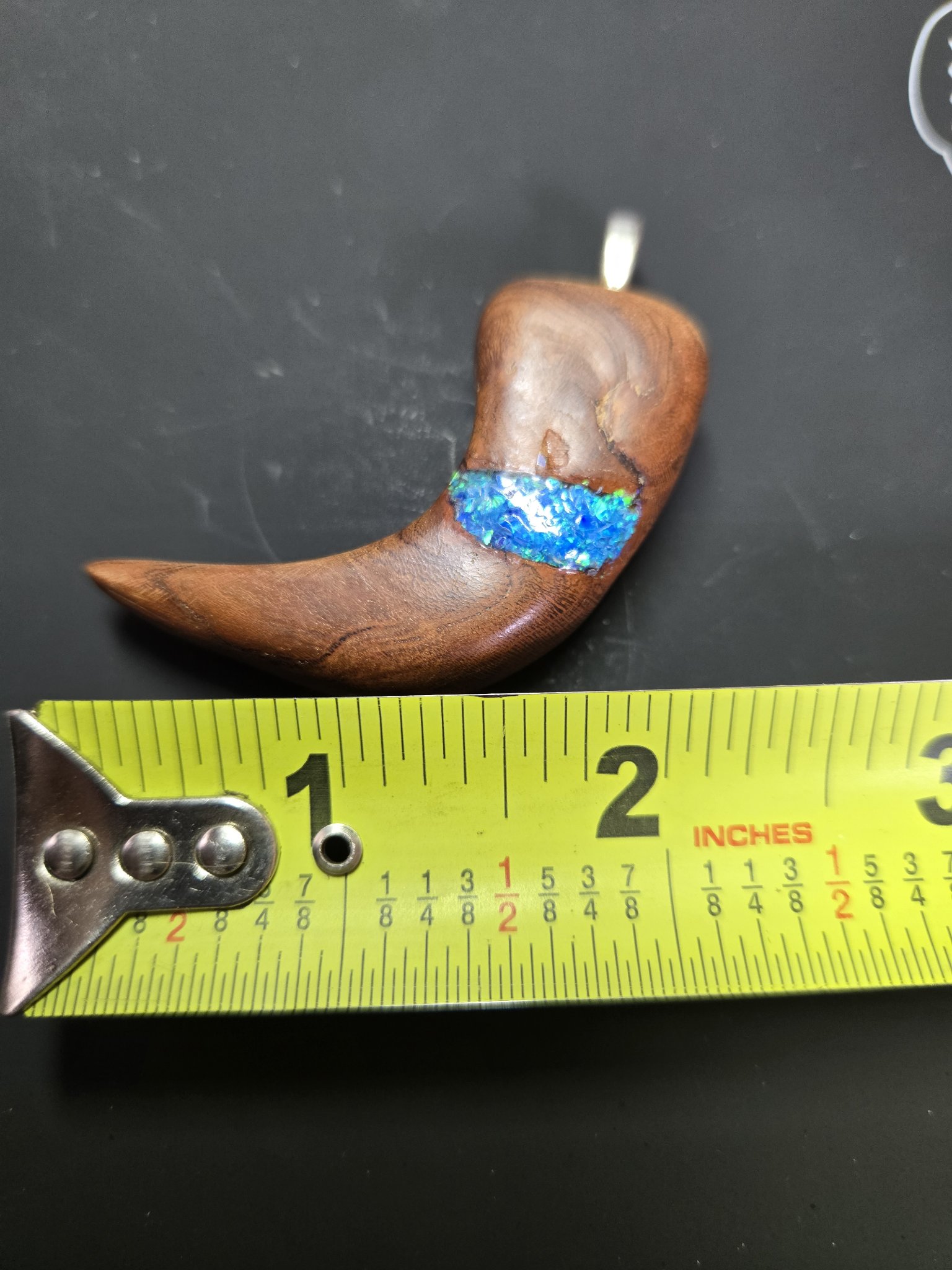 Maple bear claw pendant beside a tape measure showing it is about two and a half inches long