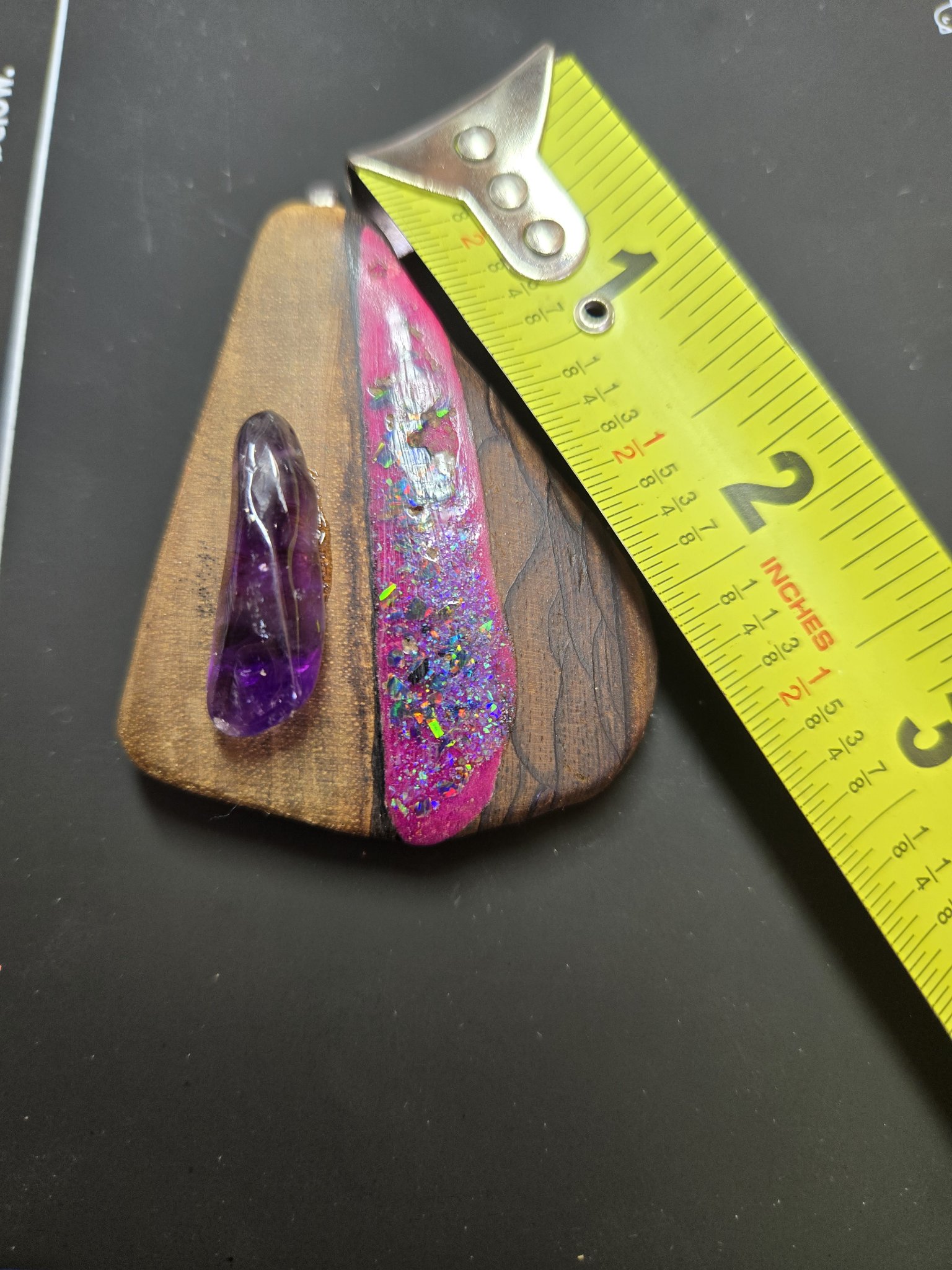 Figured maple amethyst pendant beside a tape measure showing its length