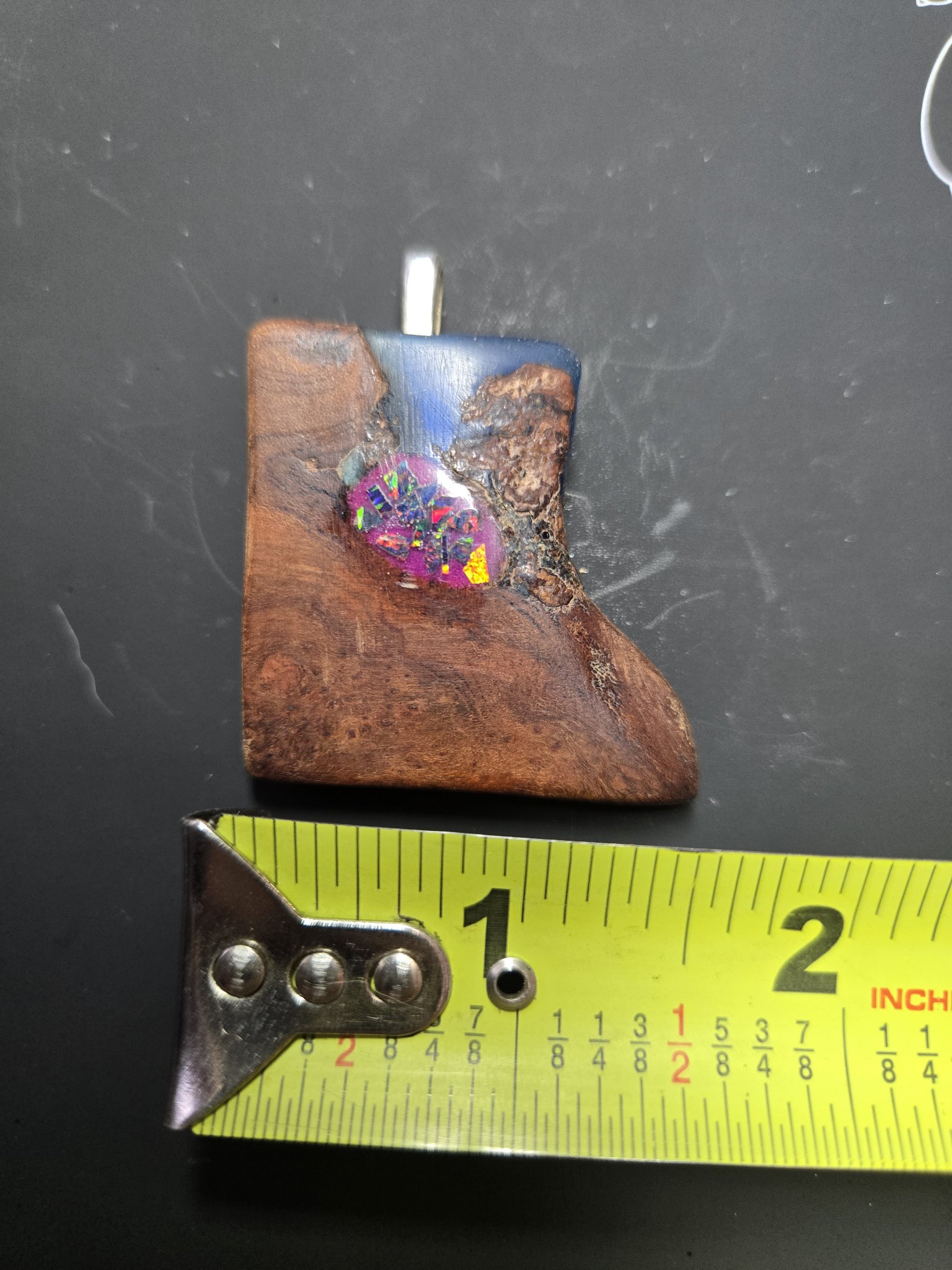 Maple blue resin and glow opal pendant above a tape measure showing it is about two inches wide