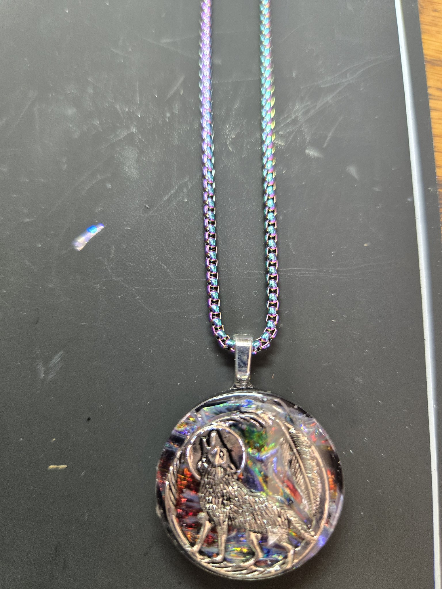 Close front view of the howling wolf holographic resin pendant with its rainbow chain
