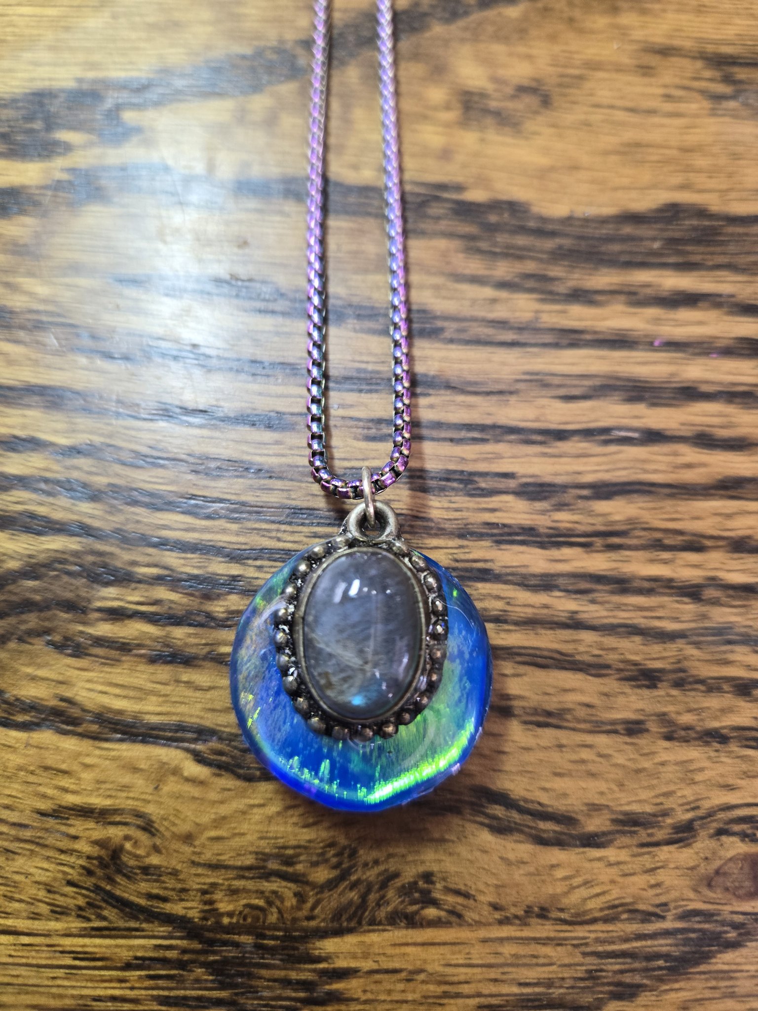 Angled front view showing the labradorite cabochon and purple, gold, and pink color-changing holographic background