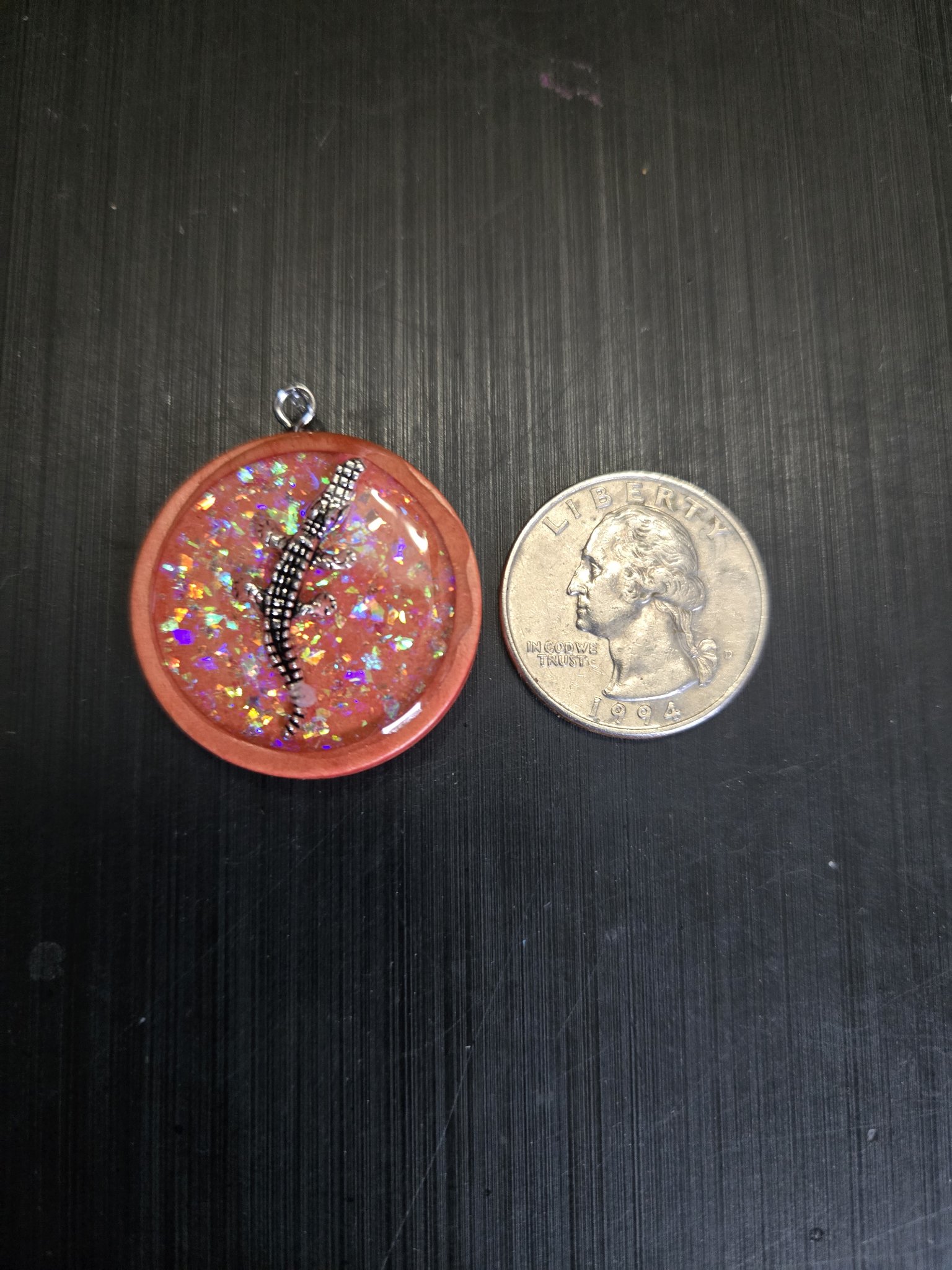 Holographic alligator pendant beside a quarter showing it is approximately one and a half inches across