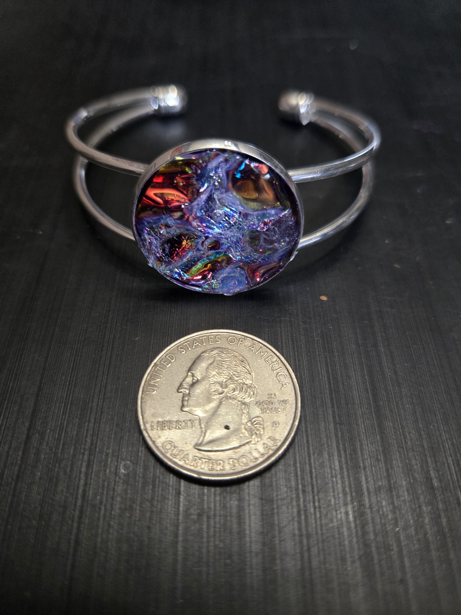 Stock 143 plain holographic resin cuff bracelet beside a quarter showing the medallion is approximately one and a half inches across