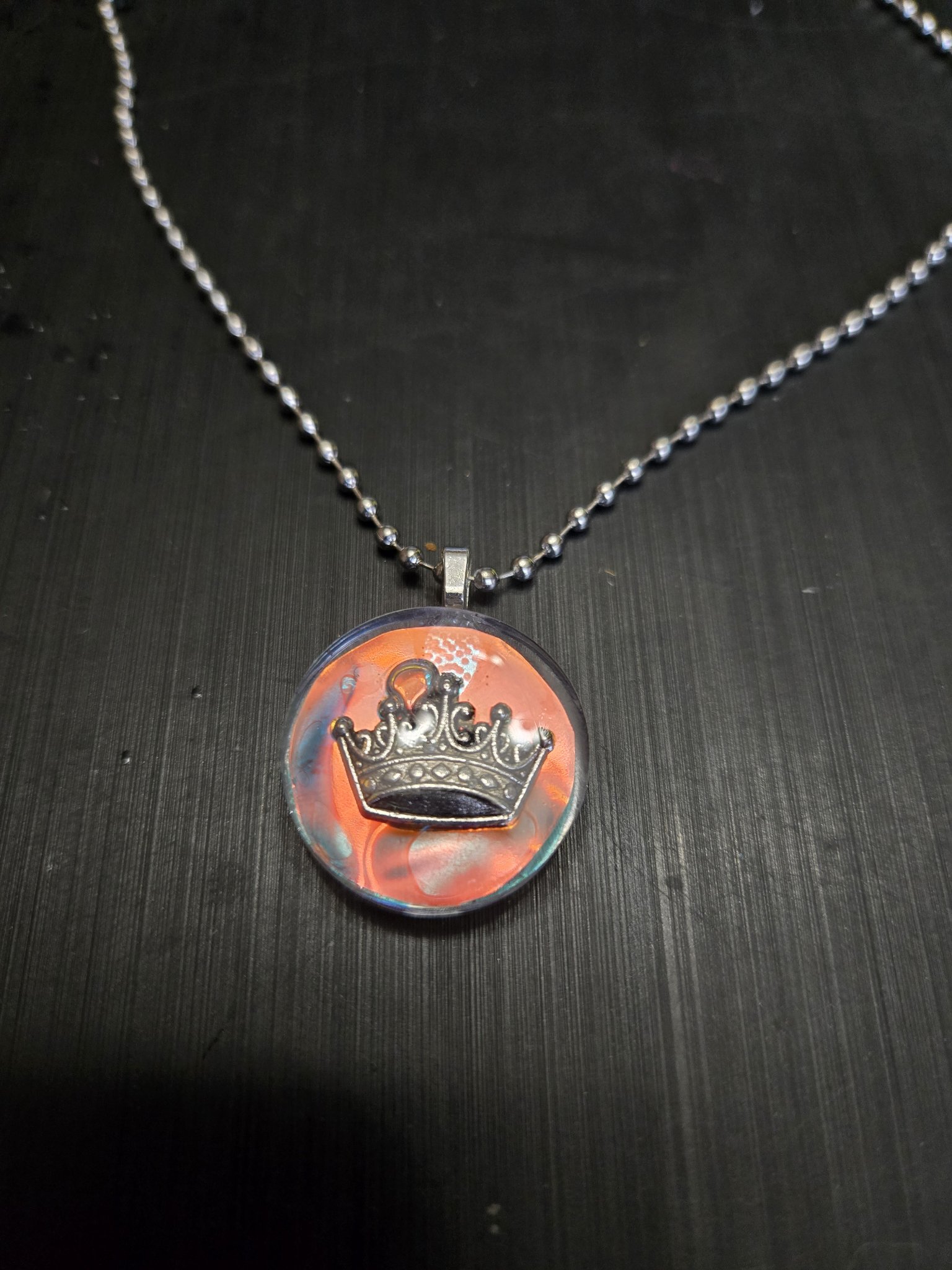 Stock 146 round orange-red iridescent holographic resin pendant with a silver-tone crown charm on a ball chain