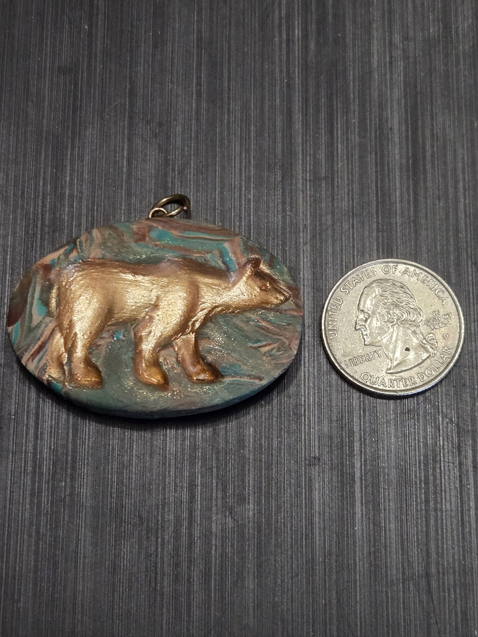 Front of stock 153 with its gold grizzly bear relief beside a quarter for scale