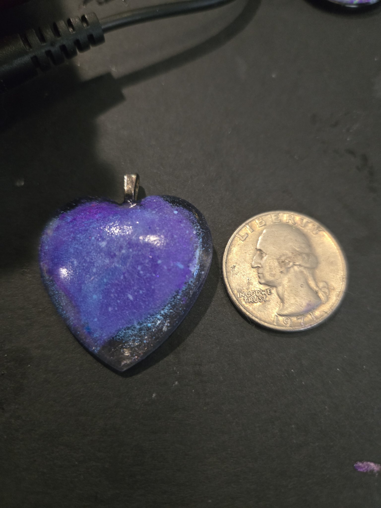 Stock 197 heart-shaped resin pendant shown beside a quarter for scale