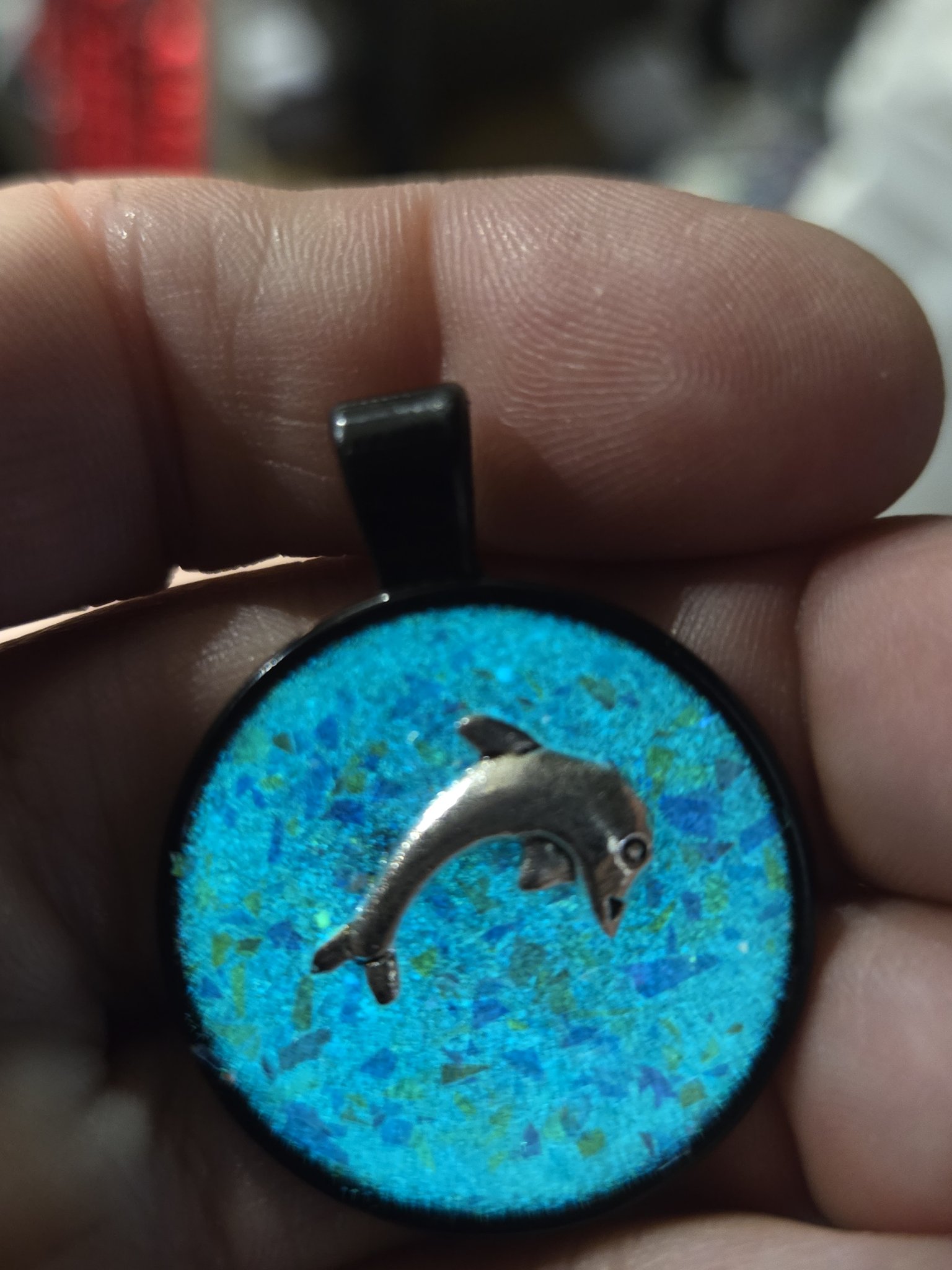 Stock 201 dolphin resin pendant glowing blue in the dark