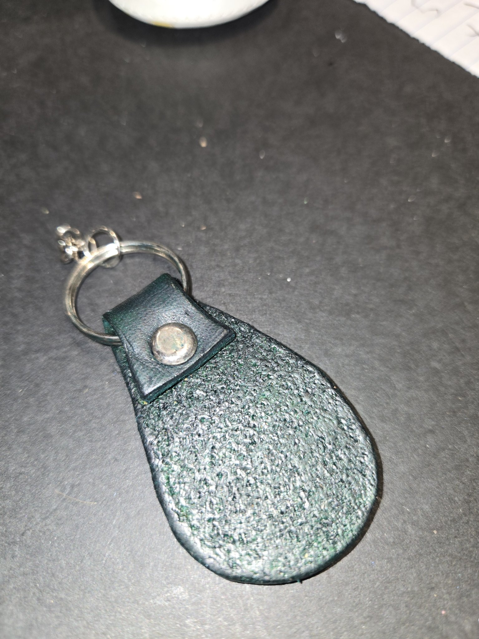 Back of stock 233 showing the textured dark green leather and the riveted loop holding the split key ring