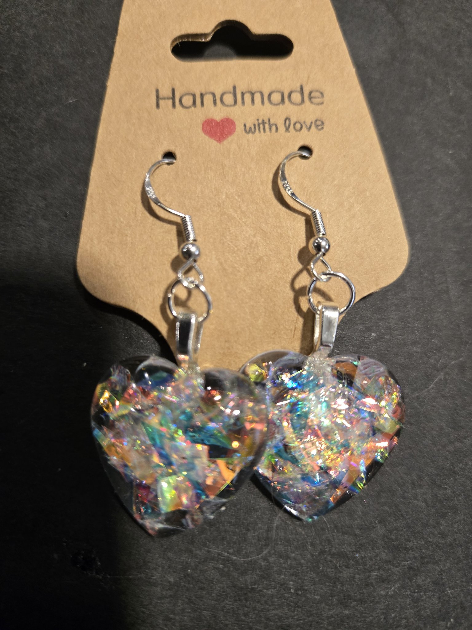 Closer view of stock 246 holographic heart earrings showing the blue, pink, green, and gold sparkle in the hearts