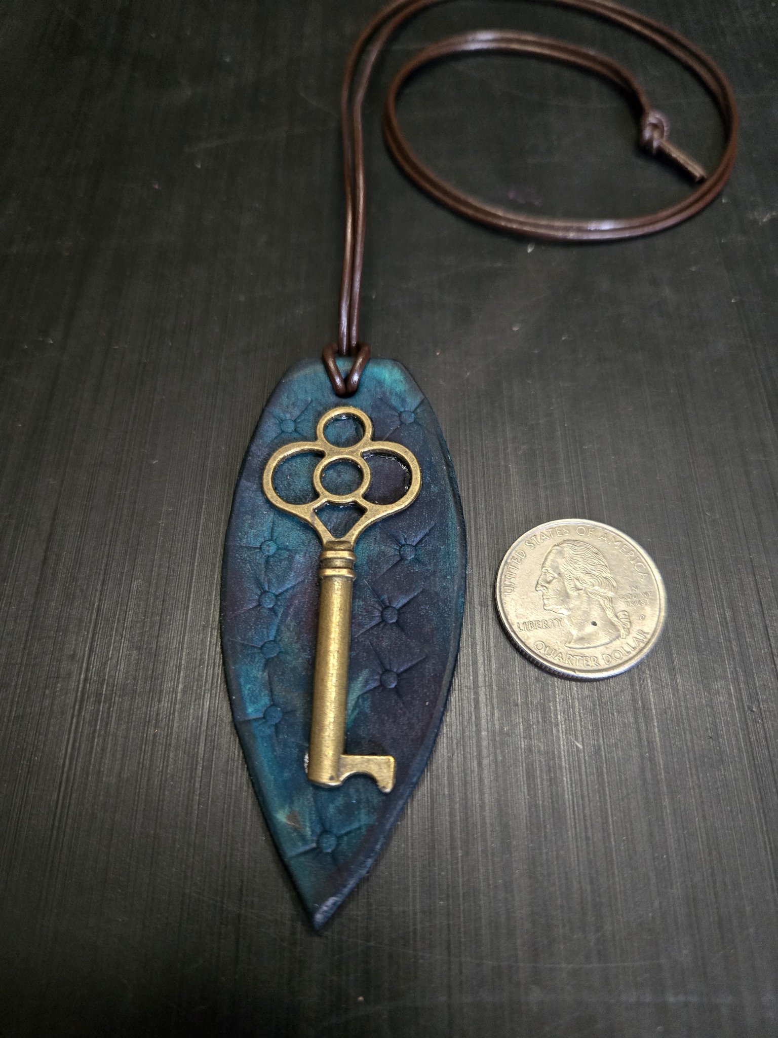 Stock 144 teal leather key pendant beside a quarter for scale