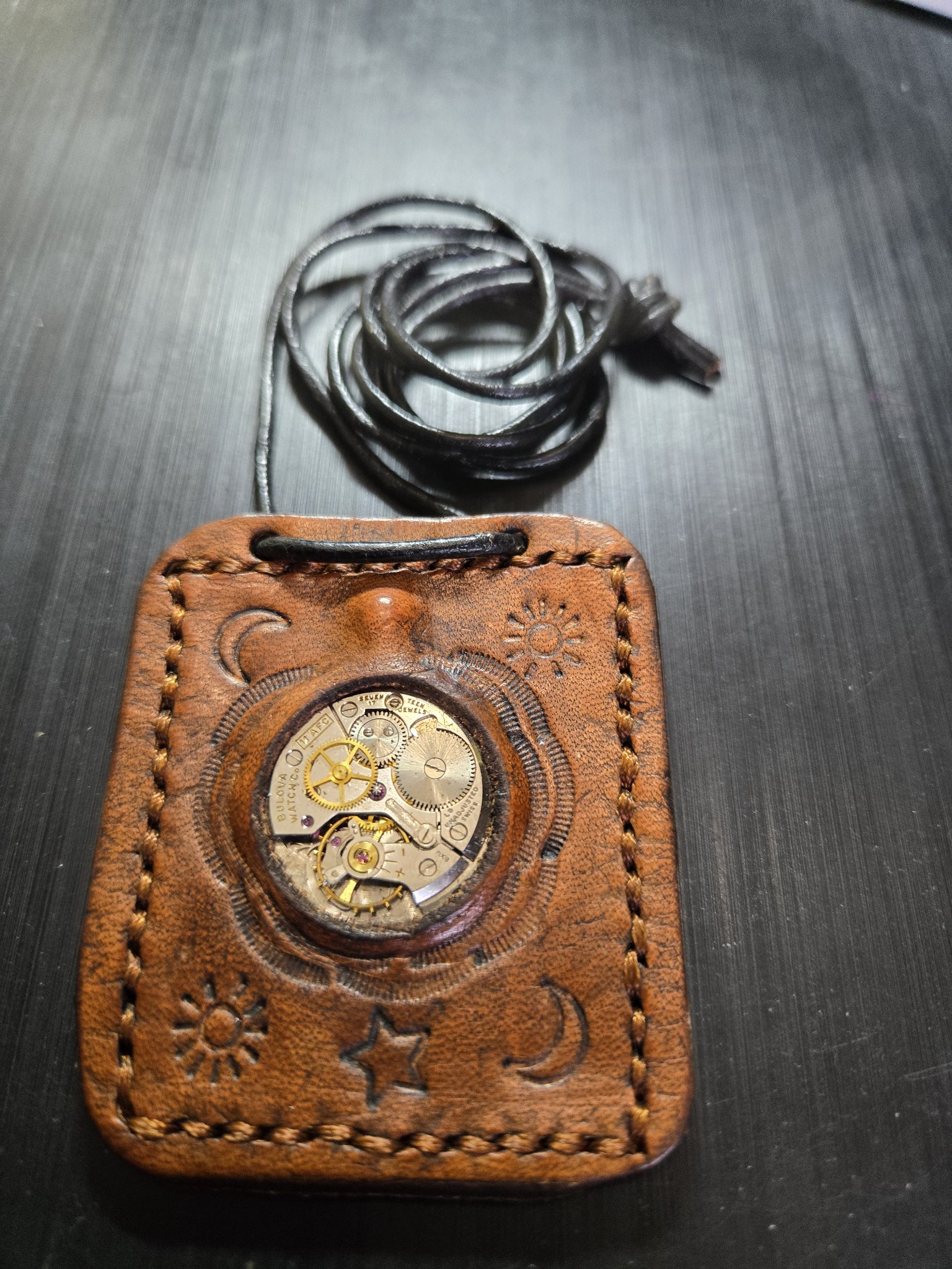 Stock 159 hand-sewn brown leather pendant with genuine Bulova watch movement, sun, star, and moon stamping, and black leather necklace