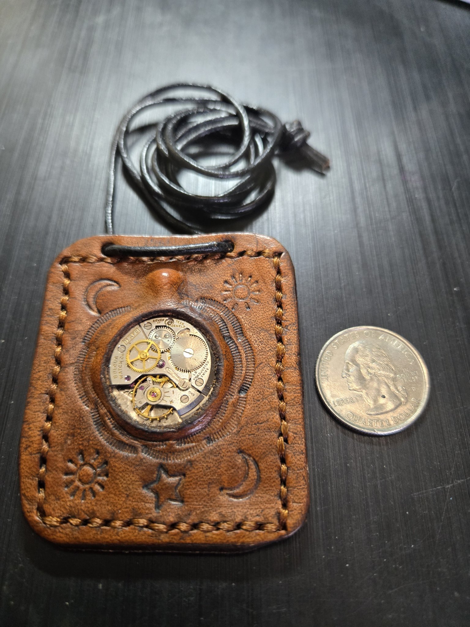 Stock 159 brown leather Bulova watch movement pendant beside a quarter for scale