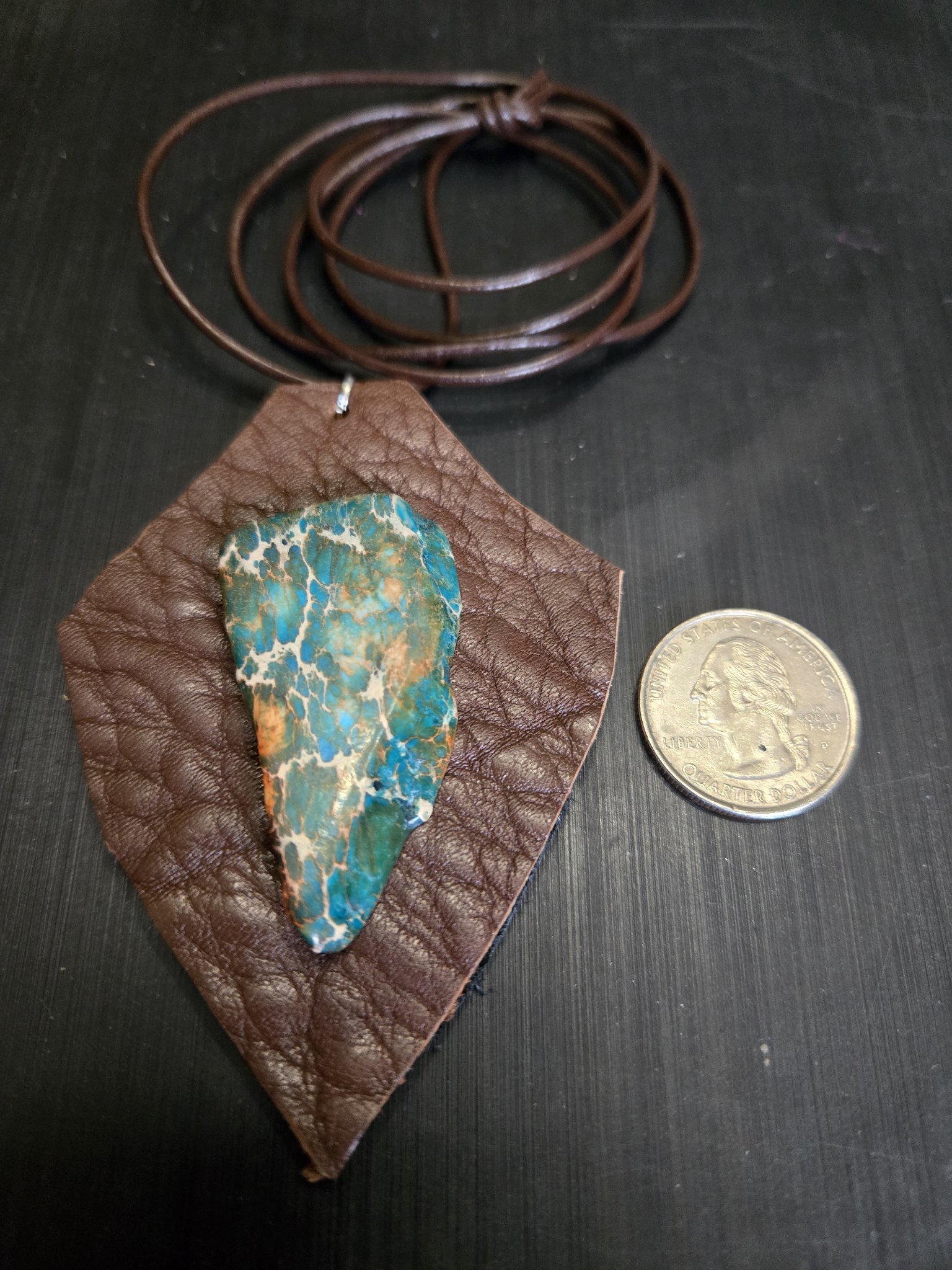 Stock 164 buffalo leather and agate pendant beside a quarter for scale