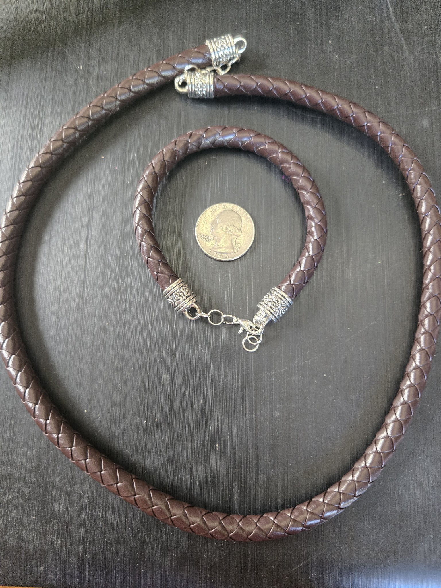 Stock 194 braided brown leather necklace and bracelet set shown beside a quarter for scale
