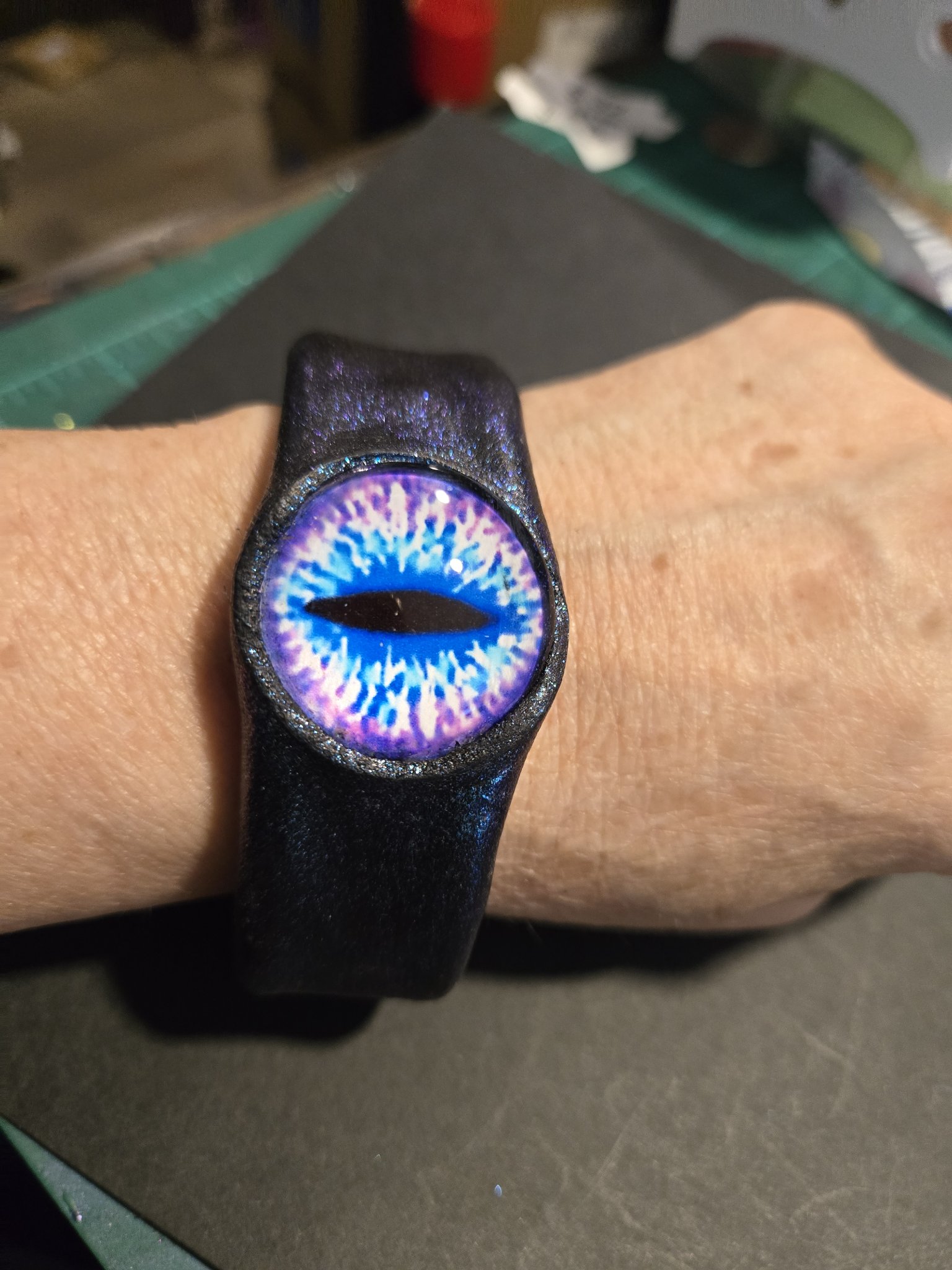 Stock 219 blue sparkle leather cuff with a vivid blue dragon eye, shown on a wrist
