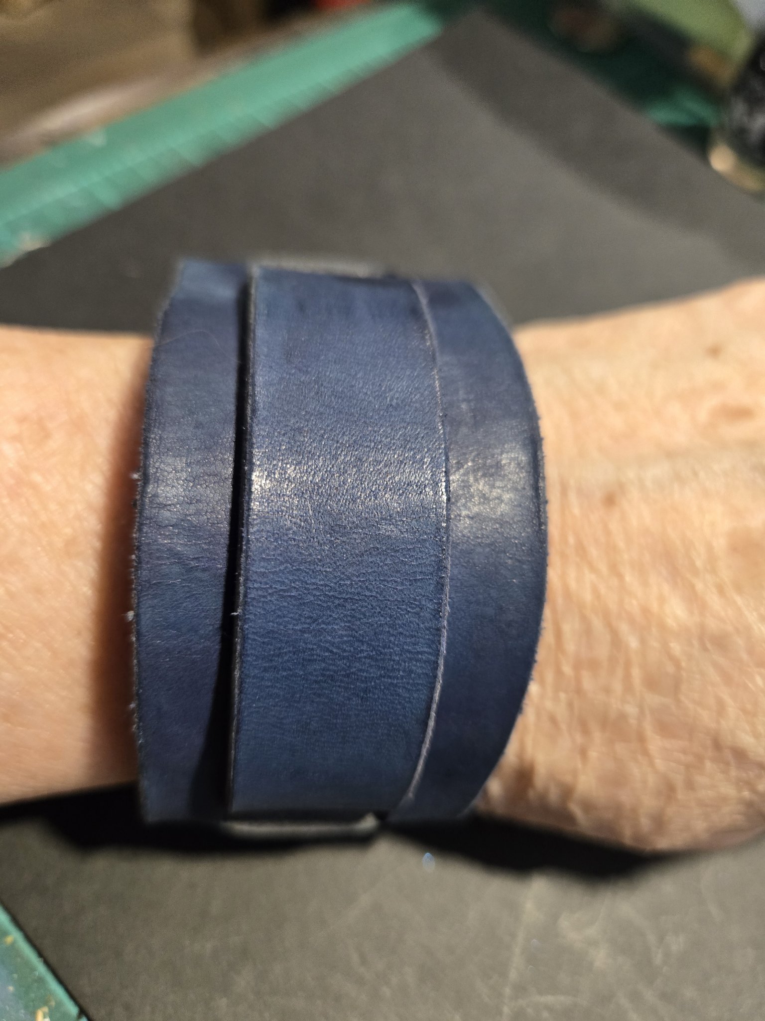Stock 225 dark blue leather cuff with a layered wrap design, shown on a wrist