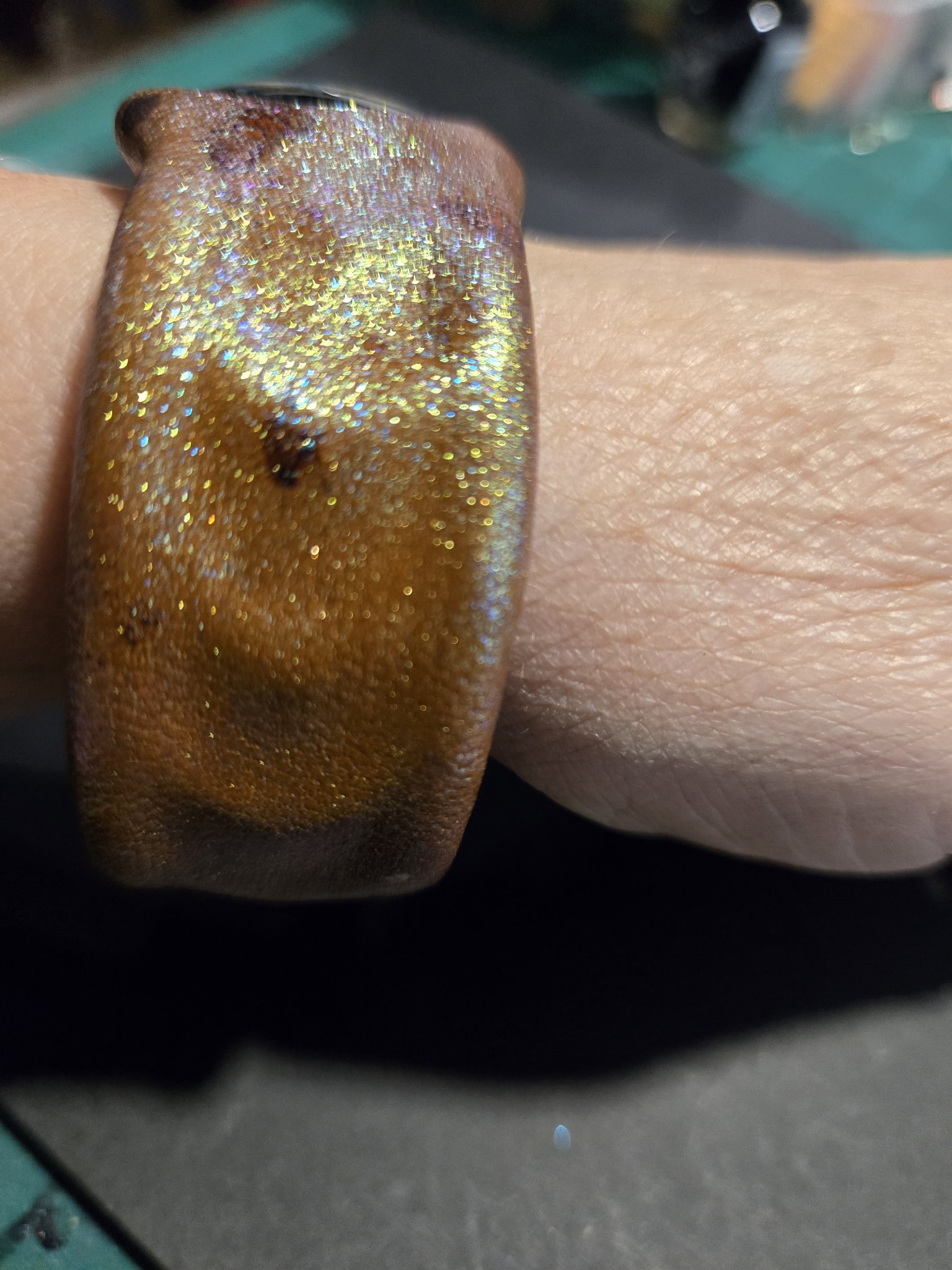 Side view of stock 226 on a wrist showing the yellow and blue sheen shimmering across the leather