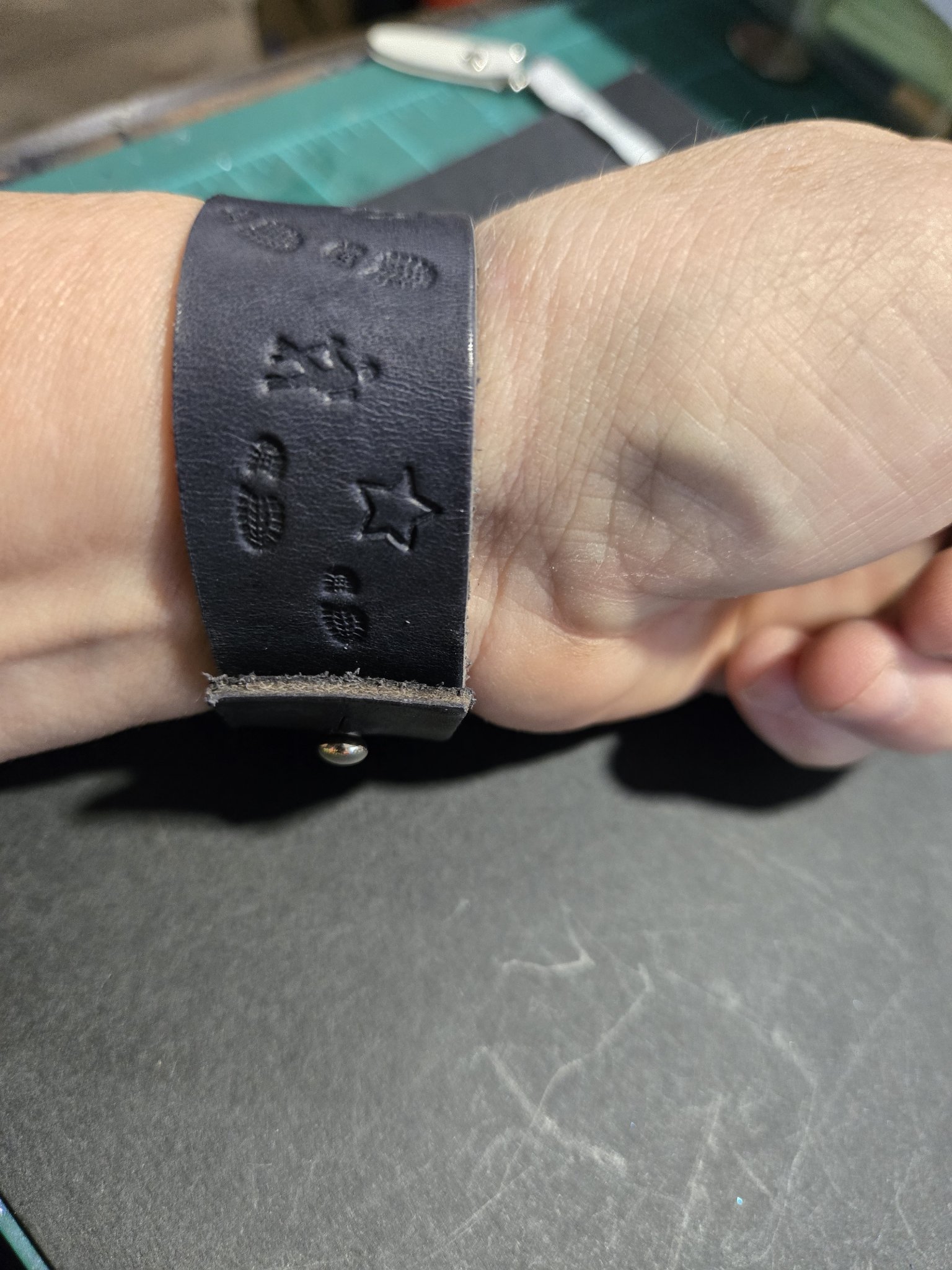 Stock 228 on a wrist showing its button closure and stamped boot prints