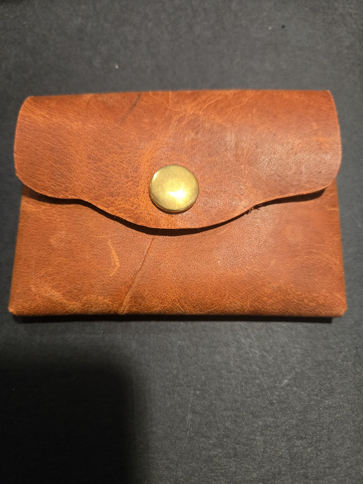 Stock 245 brown leather card and money holder closed, showing the envelope-style flap and big brass snap closure